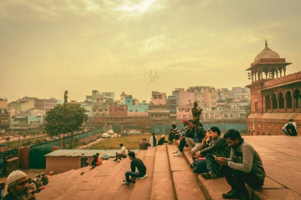 people sitting on brown concrete bench during daytime
