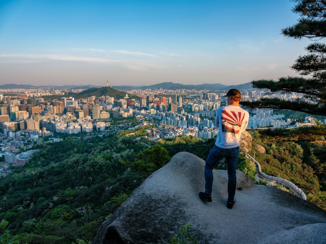 a man standing on top of a cliff overlooking a city